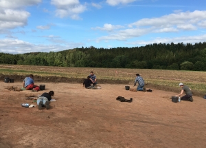 Sch&uuml;lerinnen und Sch&uuml;ler mit Dirk Keil und Grabungsleiter Gabriel Heeren auf einer der ge&ouml;ffneten Grabungsfl&auml;chen