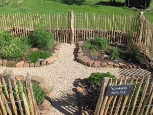 Ein Blick vom Eingang zum 6-Pfostenbau auf den Kr&auml;utergarten