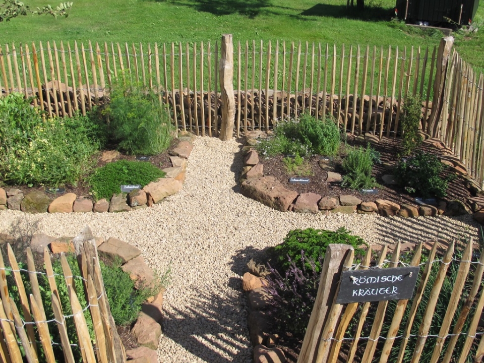 Ein Blick vom Eingang zum 6-Pfostenbau auf den Kr&auml;utergarten